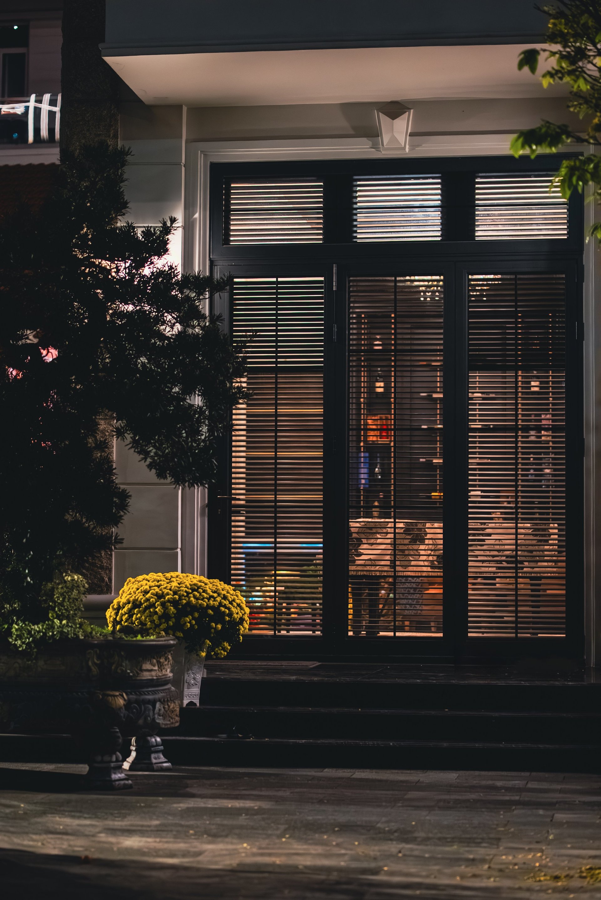 Stylish villa entrance with modern wooden door and cozy evening lighting in tropical home