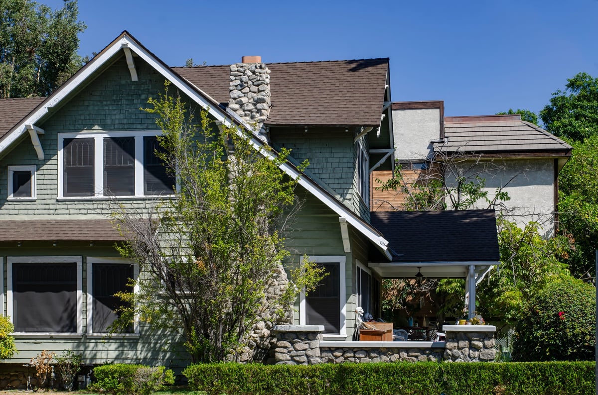 A single family home with a garden in a sunny suburban neighborhood
