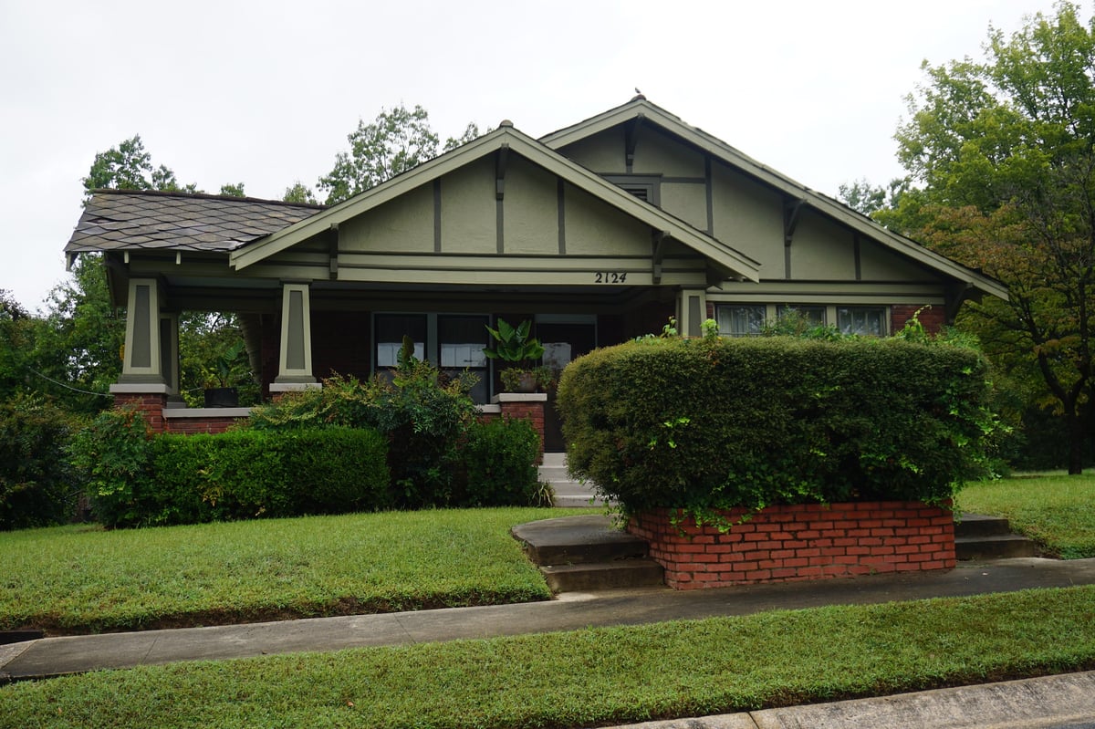 A well-preserved craftsman-style home with a brick-pier porch