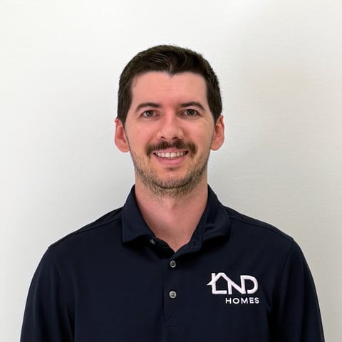 Man smiling at camera wearing dark navy polo shirt with END Homes logo